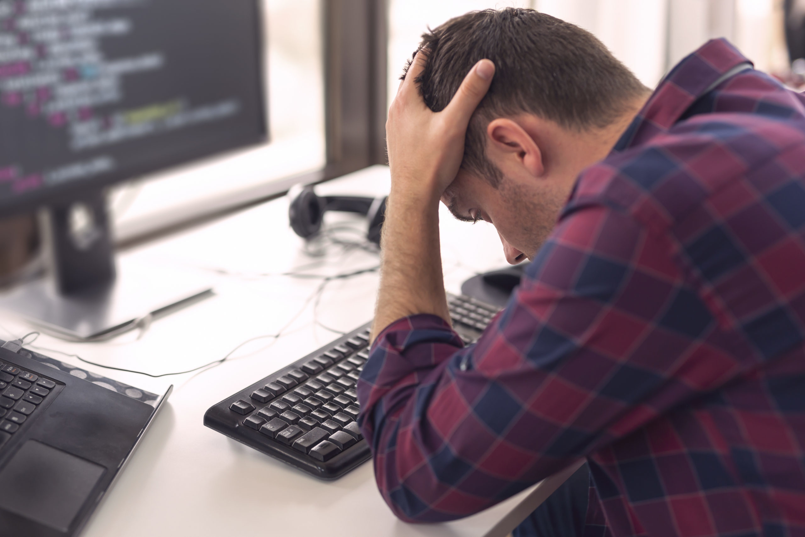 A frustrated employee stretched to thin on the computer.